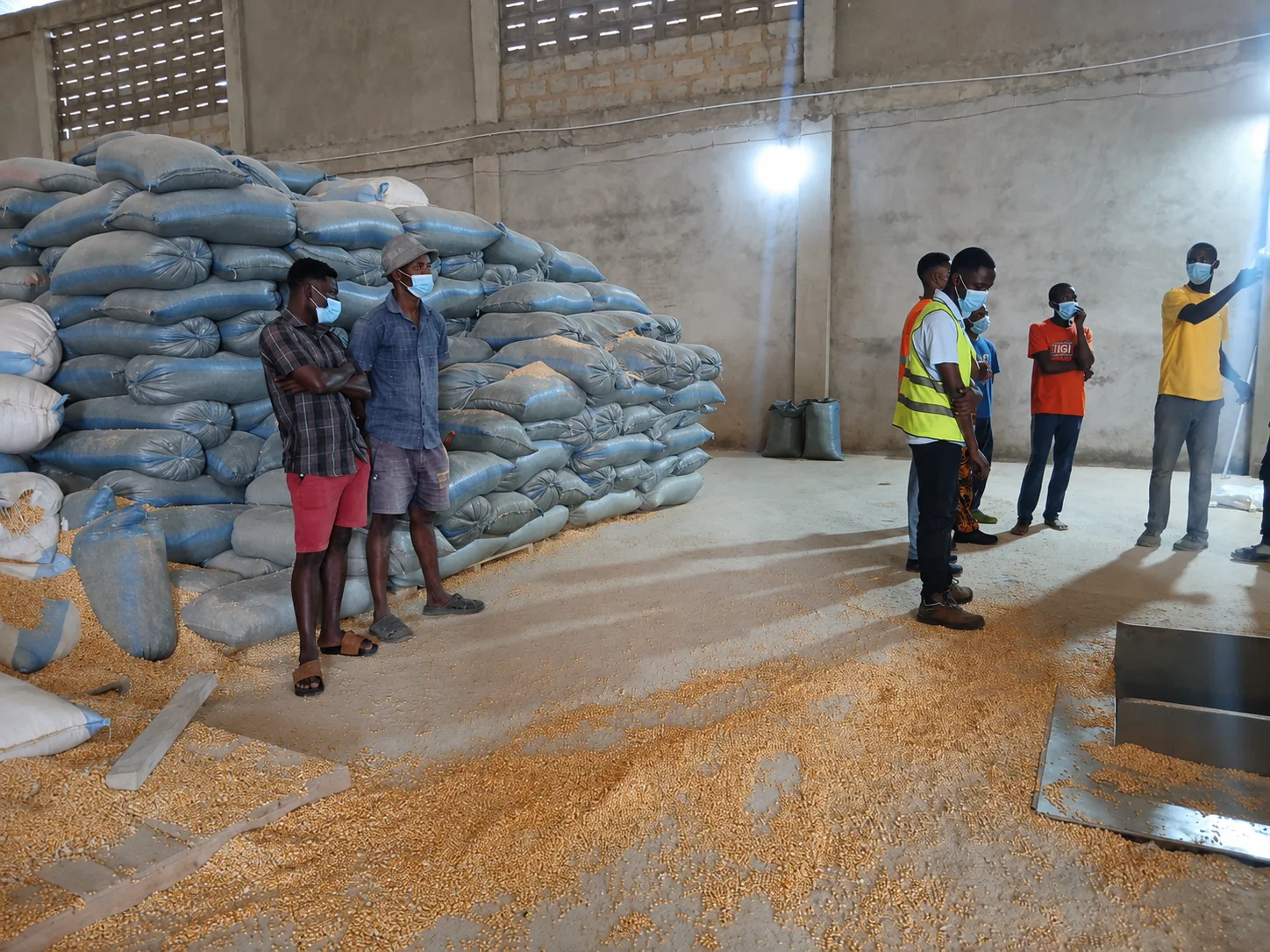 Extech staff and Kuapa Dwaso representatives discussing maize storage inside a warehouse in Takoradi